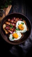 Fresh farm to table breakfast featuring eggs, bacon, and toast with herbs in a rustic bowl on a dark wood table photo