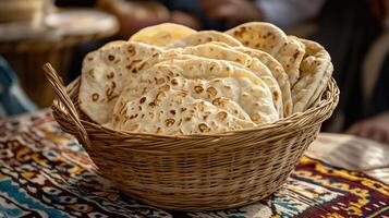 Freshly baked bread in a woven basket on a colorful textile background photo