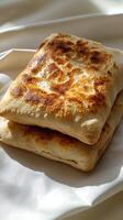 Golden brown flatbreads stacked on a creamy white background photo