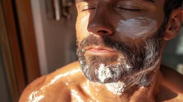 Close-up of a man with shaving cream on his face relaxing in natural light photo