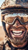 Close-up of a mud-covered motocross rider smiling with protective gear photo