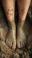 Bare feet covered in mud while standing in wet soil photo