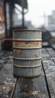 Rusty metal barrel on wooden deck with industrial background and soft bokeh effect photo