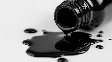 Black paint spilled from bottle on white surface photo