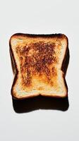 Close-up of a beautifully burnt toast slice with a crispy texture against a minimal background photo