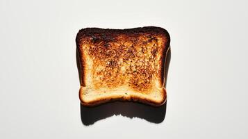 Charred toast slice on white background with golden brown edges and shadows photo