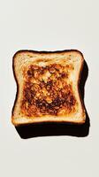 Burnt toast slice with unique texture on plain background photo