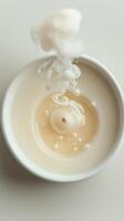 Close-up of swirling cream and wax in a white bowl creating an abstract pattern photo
