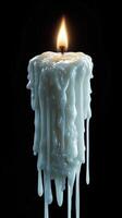 Dripping white candle wax with a flickering flame on a black background photo