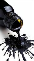 Spilled black paint pouring from a bottle creating artistic splatter and glossy texture photo
