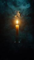 Glowing candle flame surrounded by mystical smoke and darkness photo