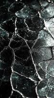 Close-up of cracked black glass with intricate texture and reflections photo
