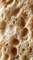 Close-up of textured bread crust with holes and bubbles, showcasing the intricate structure of baked goods photo