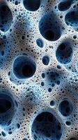 Abstract close-up of textured surface with spherical holes and intricate patterns in blue tones photo