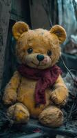 Abandoned teddy bear with a red scarf in a neglected environment photo