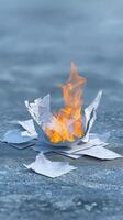 Burning crumpled paper flames on a cold surface, abstract fire and smoke illustration photo