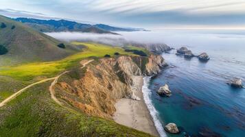 Aerial view of rugged coastal cliffs and misty shoreline at dawn photo