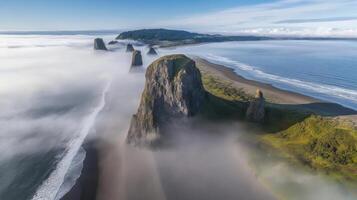 Majestic coastal landscape with towering sea stacks and rolling fog at ocean shore photo