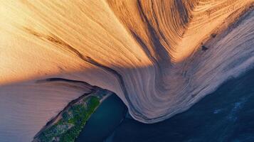 Aerial view of desert sand dune patterns with shadows and vegetation photo