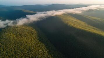 Aerial view of verdant mountain range with rolling clouds at sunset photo