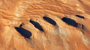 Aerial view of mars-like desert landscape with eroded rock formations and deep shadows photo