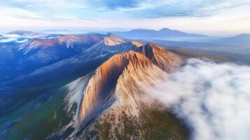 Aerial view of majestic mountain range with clouds and sunset light photo