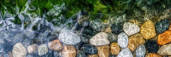 Abstract pattern of multicolored stones under clear water with natural light reflections photo