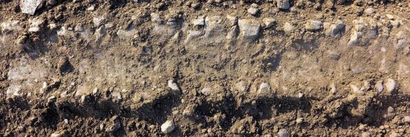 Aerial view of rough tire track on dirt road with rocky terrain photo