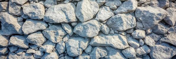 Textured surface of natural stone wall piled with large gray rocks photo
