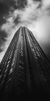 Low angle view of a tall skyscraper reaching into the dramatic cloudy sky photo