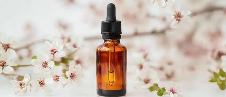 A bottle of essential oil sits on a table with flowers photo