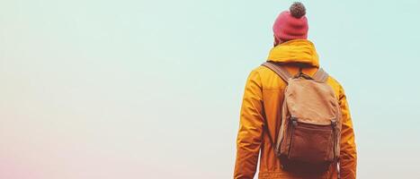 A person with a backpack standing in front of a colorful background photo
