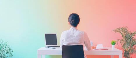 A woman sitting at a desk with a computer and a plant photo