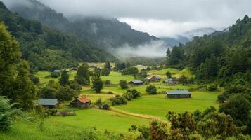 Green valley with old buildings. Mountains covered with trees and clouds. Farm houses in nature. Rural landscape with forest and cloudy sky. photo