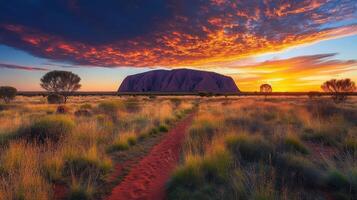 Desert landscape at sunset. Red path leads to mountain. Colorful sky above field. Australia outback scene with warm light. photo