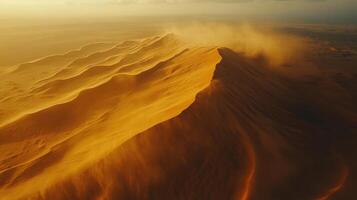 Desert sand dunes at sunset. Wind blowing off the golden dunes. Arid landscape. Abstract nature background. Sand texture pattern. photo