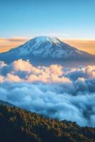 Snowy mountain peak rising above the clouds. Sunlight paints the sky. Green forest below the clouds. Peaceful, serene natural scene. photo