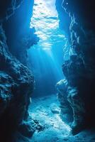 Oceano cueva. ligero brilla desde arriba. submarino escena. azul agua. rock paredes arenoso piso. pacífico vista. agua superficie es visible. foto