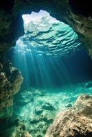 Sun rays shine into sea cave. Light goes through clear water. Rocks surround the area. View of marine environment under water. photo