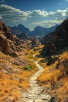 Stone path winding through valley. Mountains rise in distance. Cloudy sky above landscape. Dry grass grows beside trail. Explore nature. photo