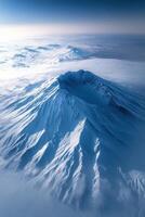 Snowy mountain peak. High angle view of a mountain top with snow. Blue sky and white clouds surround the landscape. photo