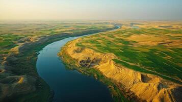 River runs through flat land. Waterway aerial. River winding through fields. Landscape river aerial view. Water flowing from up high. photo