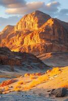 Desert landscape view. Sand and rock formations. Golden light on the mountains. Scenic nature. Arid environment with dry grass. photo