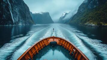 Ship sailing through fjord. Tall cliffs on both sides. Water is dark and rough. Mountains have snow on peaks. photo