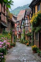 Village street view. Old buildings with flowers. Cobblestone road in town. Summer scene. Beautiful architecture. Colorful plants climb the walls. photo