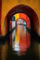 Colorful canal town view. Vivid colors reflect water. Tunnel arches over small canal. Peaceful waterway scene. Building reflection in water. Archway over the canal. photo