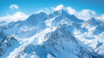 Snowy mountains under bright blue sky. Tall peaks covered in white snow. Beautiful landscape with light clouds. Winter scene in nature. photo