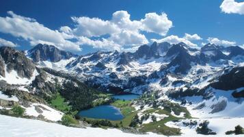 Mountain peaks covered in snow under blue sky. High view of lakes and green forest. Scenic landscape of nature and weather. photo