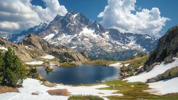 Mountain lake view. Snow on mountain peaks and blue sky with clouds. Natural landscape with water and rocks in summer. photo
