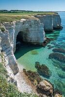 Coast cliffs view. Clear water meets tall rocks. Green grass on top. Beautiful landscape in summer day. Coastal scene with the sea. photo